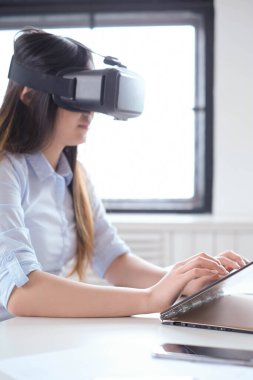 Çalışırken kulaklık takan Asyalı bir kadın.