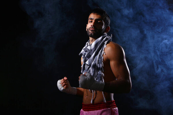 Молодой и сильный боксёр на тёмном фоне