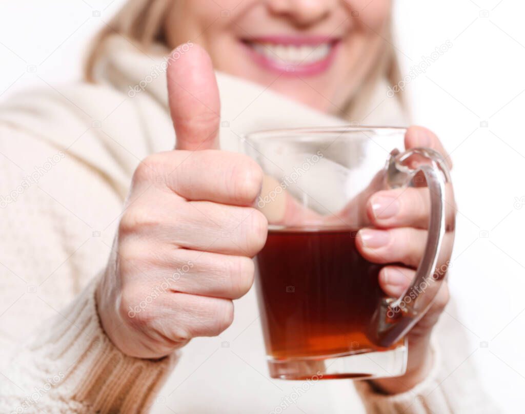  Woman drinking hot tea and shows thump up