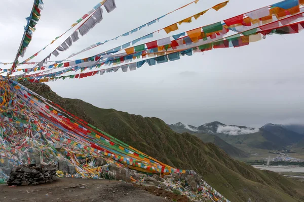 Bulutlu bir günde, Lhasa, Tibet yakınlarındaki yüksek geçitte renkli dua bayraklarıyla bir sürü ip.