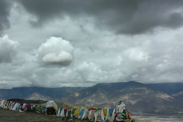 Highpass no Tibete não muito longe de Lhasa com bandeiras de oração e nuvens penduradas muito baixo — Fotografia de Stock