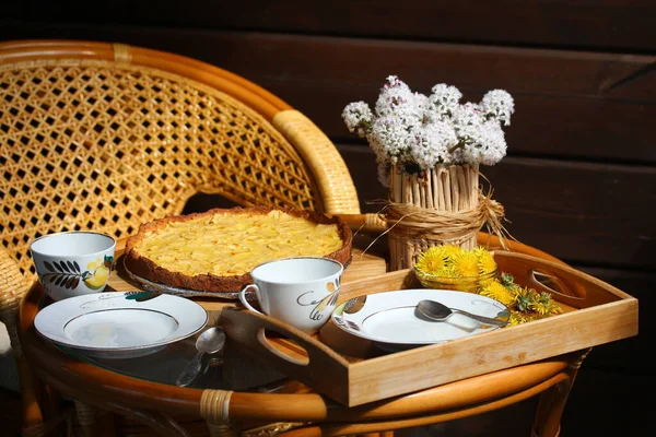 Tea party sulla terrazza. Crostata di mele e vaso di fiori sul tavolo. — Foto Stock