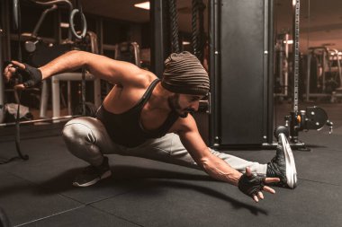 Spor salonunda sakallı bir sporcu Yoga ve Dövüş Sanatları egzersizi yapıyor. Yoga zihinsel faydaları.