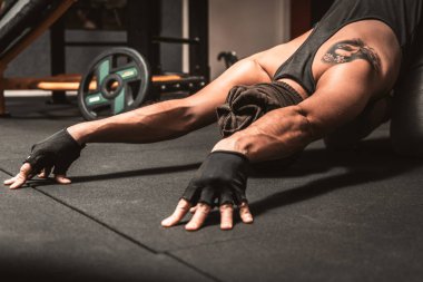 Spor salonunda sporcu bir adam yoga egzersizi yapıyor. Sırt germe egzersizi. Yoga pozisyonu Sasangasana. Yoga zihinsel faydaları.
