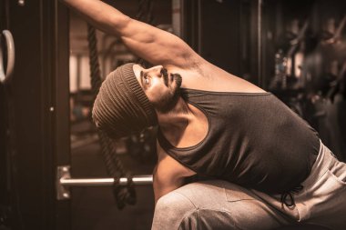 Spor salonunda sakallı bir sporcu Yoga ve Dövüş Sanatları egzersizi yapıyor. Vahşi Savaşçı Yoga Pozu Dizisi. Utthita Parsvakonasana Yoga Konumu