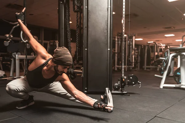 A bearded sporty man in the gym is doing Yoga and Martial Arts exercises. Yoga mental benefits.