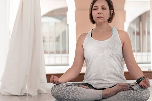 Yoga teacher sitting in the lotus position. Woman practicing Yoga. How to Keep Your Arms  for a Kriya or Meditation.