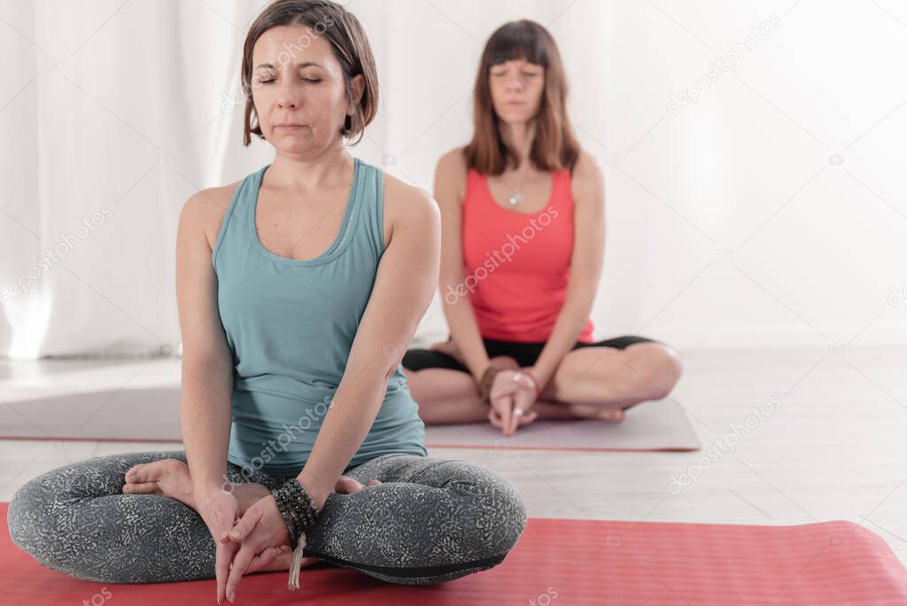 Yoga teachers sitting in the lotus position with their eyes closed. Group of people practicing Yoga. How to Keep Your Arms in the Air for a Kriya or Meditation.