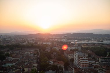Brescia şehrinin ve Alp dağlarının binalarının bulunduğu hava panoramik günbatımı manzarası, mavi bulutlu arka plan, Lombardy, Kuzey İtalya. Brescia Kalesi.