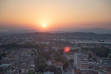 Brescia şehrinin ve Alp dağlarının binalarının bulunduğu hava panoramik günbatımı manzarası, mavi bulutlu arka plan, Lombardy, Kuzey İtalya. Brescia Kalesi.