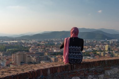 Çatıdaki terasta eski İtalyan şehri Brescia 'nın hava manzaralı akıllı Mısırlı kızı..