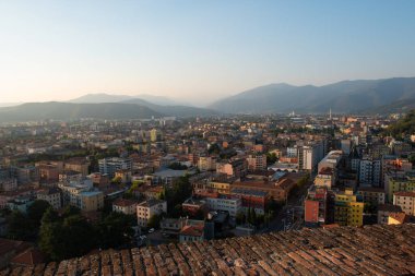 Brescia şehrinin ve Alp dağlarının binalarının bulunduğu hava panoramik günbatımı manzarası, mavi bulutlu arka plan, Lombardy, Kuzey İtalya. Brescia Kalesi.