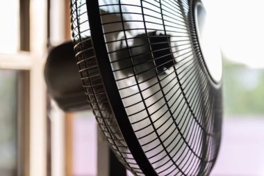 Pencerenin önündeki yelpaze türbini. Elektrik vantilatörü yavaşlar ve harekete devam eder..