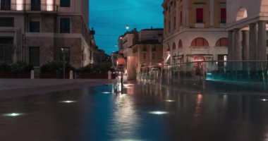 Şehir geçmişinde poz veren güzel bir kız. Meydandaki fıskiyeli trafiğin zaman ayarlı görüntüsü. Işıklar. Işık yolları. Akşamları hareket.