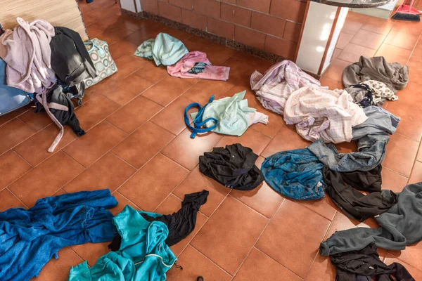 Bir kadının bir sürü giysisi vardır. Giysileri dağınıktır ve evde yere saçılmıştır.