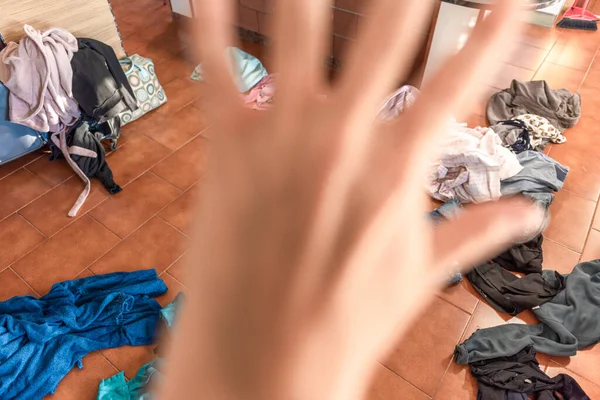 Bir kadının bir sürü giysisi vardır. Giysileri dağınıktır ve evde yere saçılmıştır.