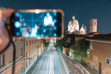 Duomo Nuovo Kubbesi 'nin akıllı telefonuyla gece görüşü şehrin hareketi, Roma Katolik kilisesi ve Brescia, Lombardiya' nın tarihi merkezi, İtalya 'nın kuzeyindeki Palazzo del Broletto Kulesi.