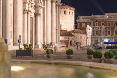 Zamanlamalı yakınlaştırma. Gece manzarası, Piazza del Duomo Nuovo 'nun şehir hareketi, Roma Katolik kilisesi ve Palazzo del Broletto' nun kulesi, Brescia 'nın tarihi merkezi, Lombardy, kuzey İtalya