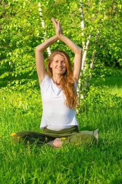 Güzel doğada yoga yapan genç bir kadın. Güneşli bir günde meditasyon