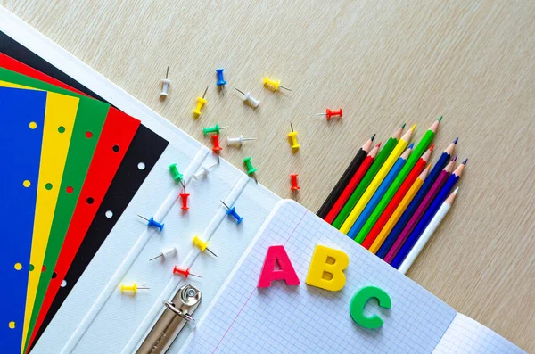 Kleurrijke samenstelling van schoolspullen en brieven op de withe houten achtergrond. Begrepen, ruimte. Plat gelegd. Terug naar schoolconcept. — Stockfoto