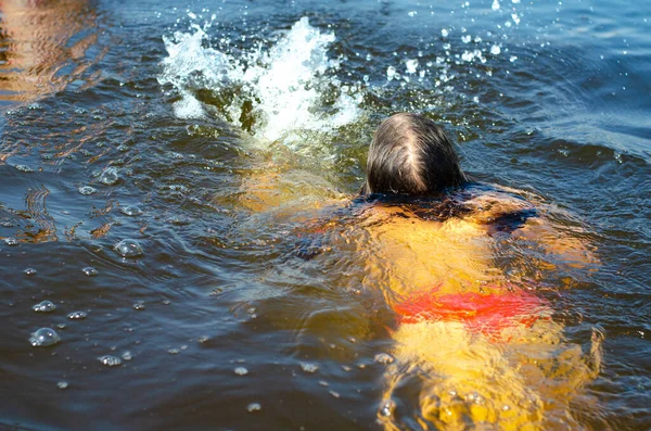 Jeune fille de six ans nageant dans un lac par une belle journée d'été. Concept de vacances. — Photo