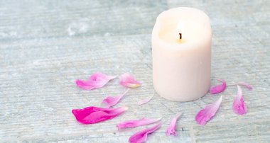 Güzel pembe şakayık yaprakları ve beyaz gri taş zemin üzerinde beyaz mum metin üstü görüntün için fotokopi alanı.