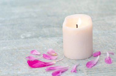 Güzel pembe şakayık yaprakları ve beyaz gri taş zemin üzerinde beyaz mum metin üstü görüntün için fotokopi alanı.