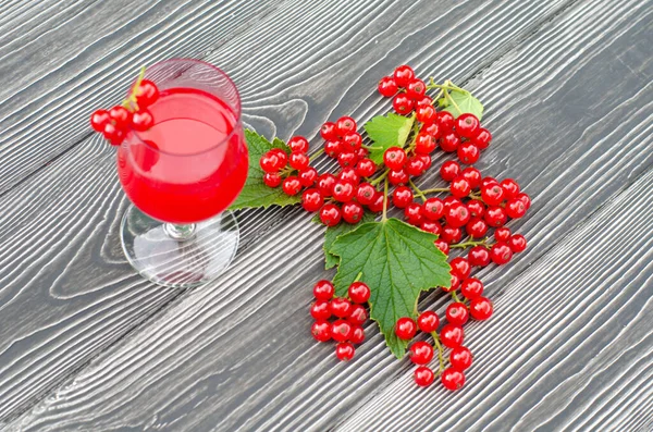 A fresh red currant drink and juicy berries on a wooden table in the green garden. Top view, copy space. — Stock Photo, Image