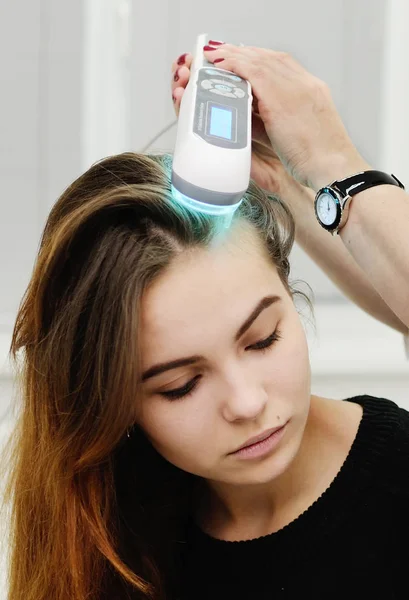 Doctor examines scalp a special device with a UV lamp — Stock Photo, Image