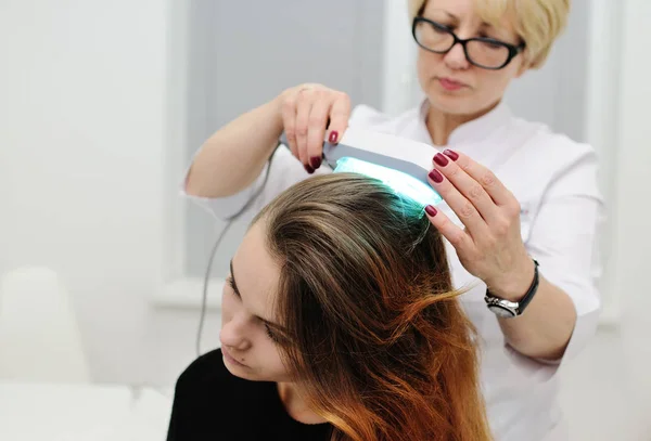 Dokter memeriksa kulit kepala perangkat khusus dengan lampu UV — Stok Foto
