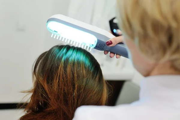 Dokter onderzoekt een speciale inrichting hoofdhuid met een UV-lamp — Stockfoto