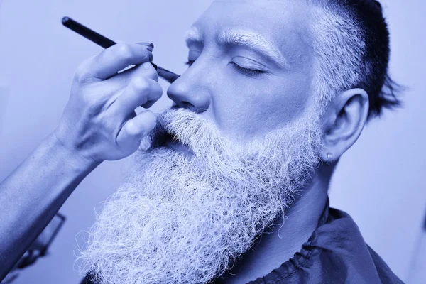 Maquillador pinta una barba de hombre, bigote y cejas en color gris — Foto de Stock