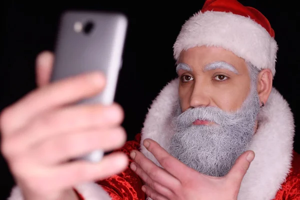 Santa Claus takes himself to the camera of a smartphone — Stock Photo, Image