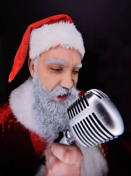 Papai Noel com um microfone canta uma canção — Fotografia de Stock
