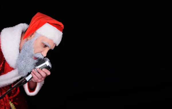Papai Noel com um microfone canta uma canção em karaoke — Fotografia de Stock