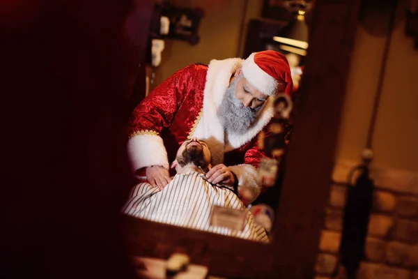 Papai Noel Barbeiro corta e rapa a barba de um homem — Fotografia de Stock