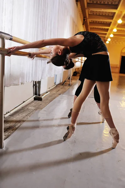Tři mladé roztomilé baleríny provádět cvičení na choreografické stroje nebo barre — Stock fotografie