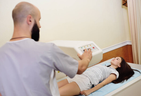 young pretty girl on examination in a modern clinic by densitometry