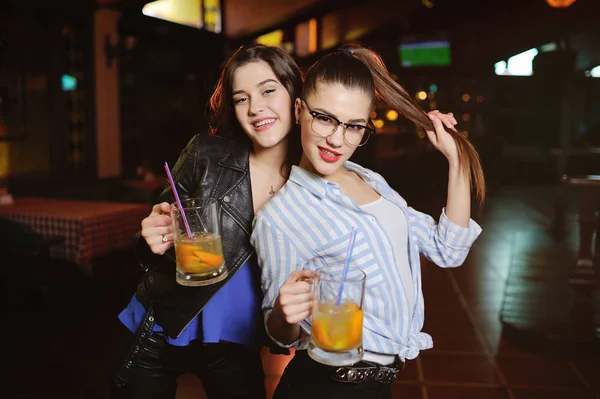 Jonge cute verleidelijke meisjes met een glas bier of een cocktail op de achtergrond van de bar bier — Stockfoto