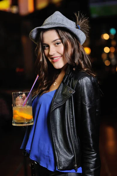 Jolie jeune fille dans un chapeau bavarois gris boit de la bière ou un cocktail de bière à travers une paille sur le fond d'un bar. Oktoberfest, St. Patricks Day — Photo