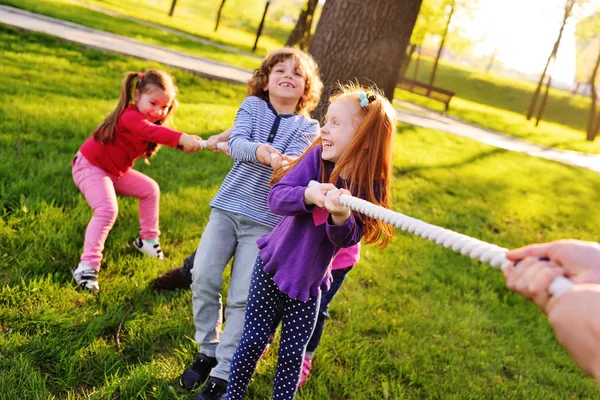 Kinderen spelen touwtrekken in het park. — Stockfoto