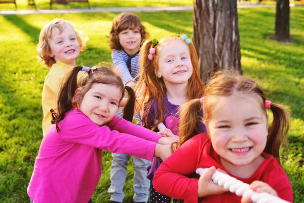 Children play tug of war in the park.