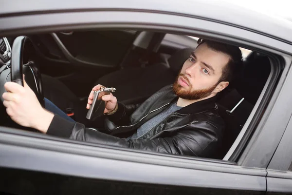 Joven conduciendo un coche con un matraz de hierro —  Fotos de Stock