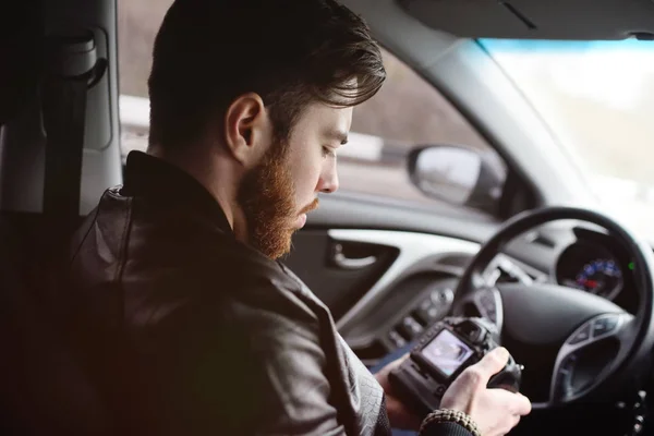 Young man with a camera in the car