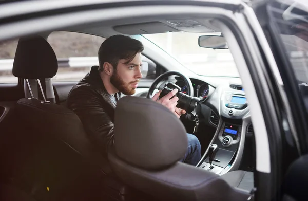 Jovem com uma câmera no carro — Fotografia de Stock