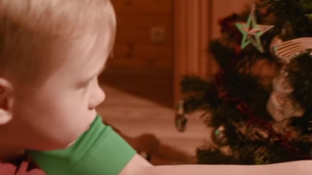 Annem ile erkek bebek elbise evde oyuncaklar Noel ağacı — Stok video