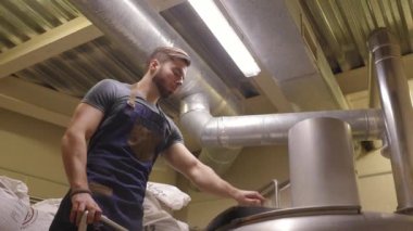 Yakışıklı bir erkek brewer kayıtları veri bira tankları çerçevede bir sakallı. Bira