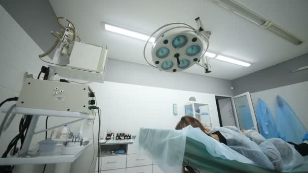 O paciente está deitado em uma cama de hospital em uma sala cirúrgica — Vídeo de Stock