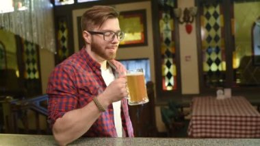 Bir bardak bira ile ekose gömlekli sakallı yakışıklı adam
