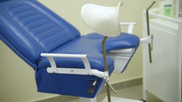 Gynekolog pratar med patienten på bakgrund av gynekologisk stol — Stockvideo